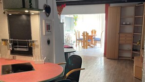 Een keuken met een ronde tafel en stoelen, een ingebouwde grill en een eethoek met houten stoelen en een tafel.