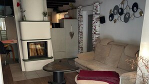 Een moderne woonkamer met een open haard, een bank, een bijzettafeltje en een decoratief kunstwerk aan de muur.