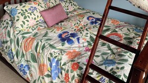 Una cama litera con ropa de cama floral y estructura de madera.