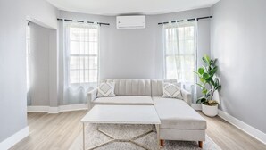 Ein modernes Wohnzimmer mit Ecksofa, Couchtisch und Topfpflanze.