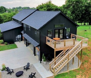 Un edificio moderno negro con una terraza y zona de estar al aire libre.