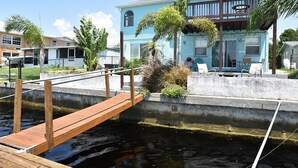 Ein Anwesen am Wasser mit Anlegesteg, Pool und einem Haus mit Balkon.