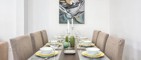 Mesa de comedor para seis personas con un cuadro abstracto moderno en la parte superior.