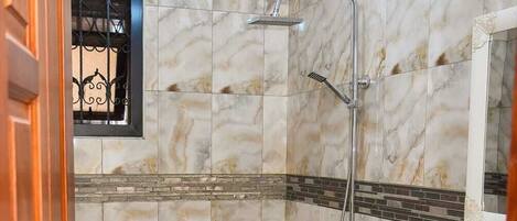 A bathroom with a toilet, a shower, and a sink.