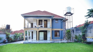 A two-story house with a balcony, a water tank, and a well. - KCube Villas Kampala (Kampala)