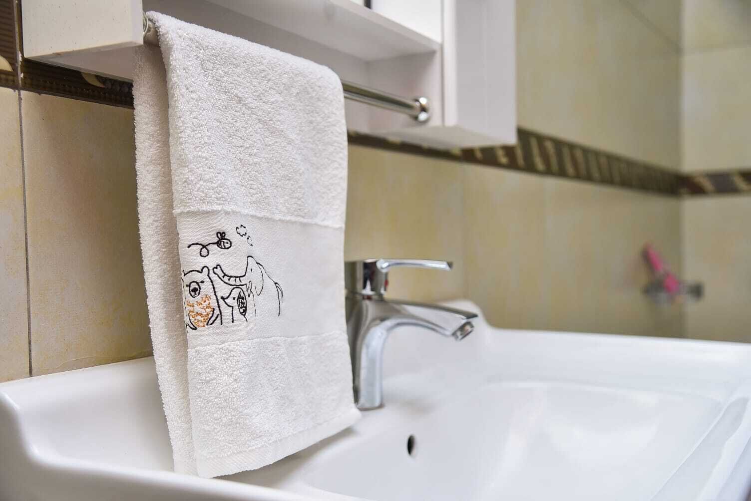 A white bathroom sink with a towel hanging on a rack.