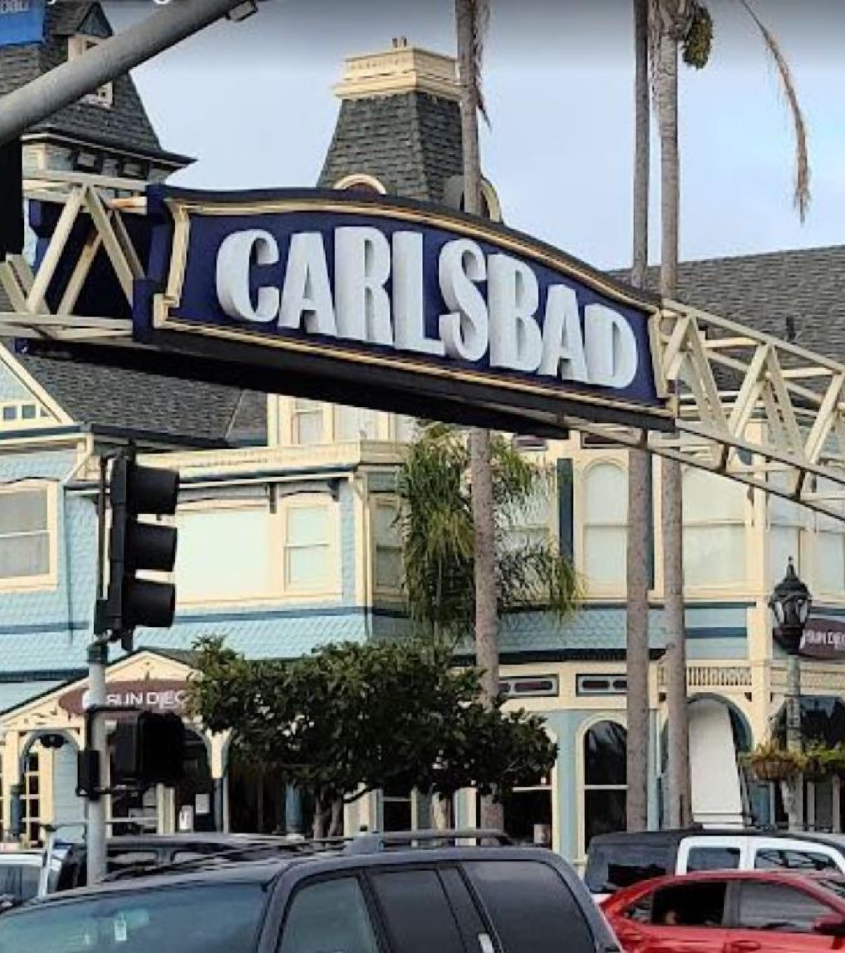 A street sign with the name 'CARLSBAD' in large white letters on a dark background.