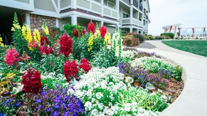 Et hotel med en anlagt have, farverige blomster og velplejet græsplæne.
