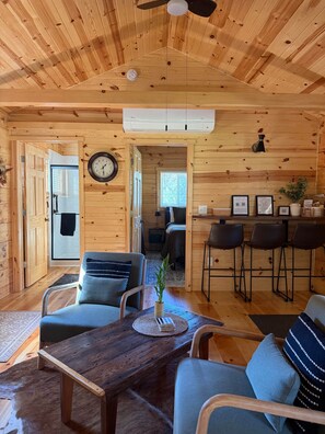 Un intérieur en bois comprenant un coin repas, des sièges et une horloge au mur.