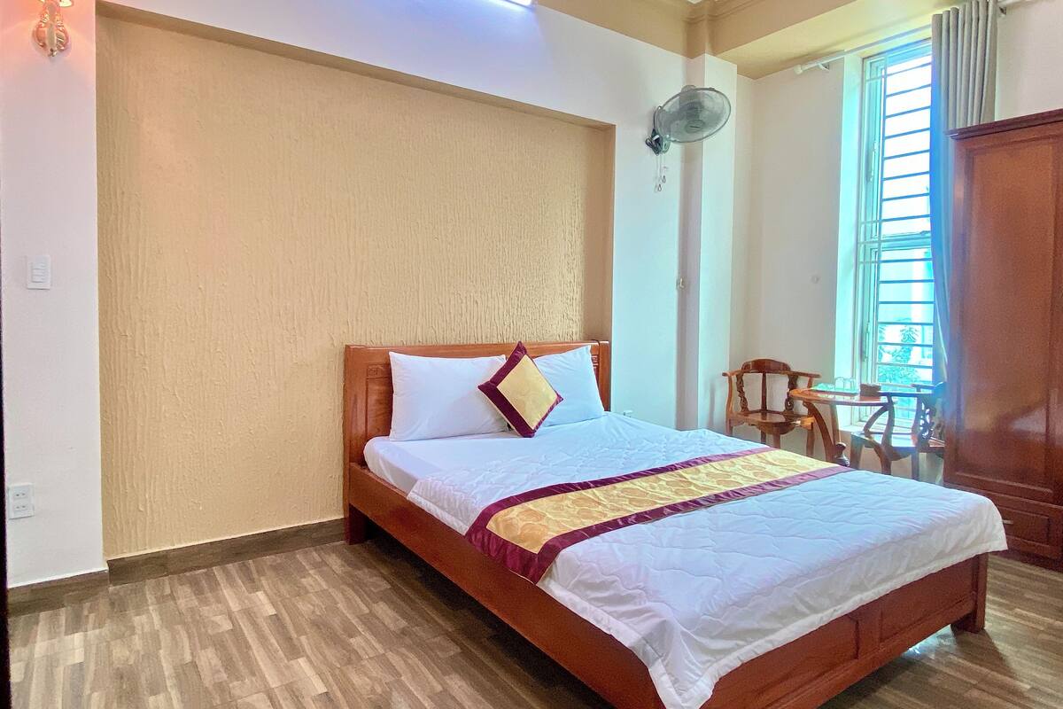 Ein Hotelzimmer mit einem hölzernen Bett, einem kleinen Tisch und einem Stuhl.