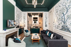 A spacious living room with a fireplace, a sofa set, a coffee table, and a television.