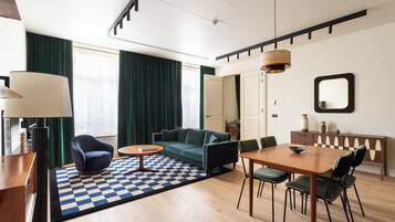 A modern living room with a sofa, coffee table, and dining area.
