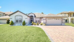 Una casa residenziale con vialetto, garage e un prato curato.