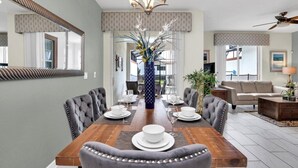 A dining area with a wooden table, grey upholstered chairs, and a decorative vase.