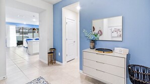 A hallway with a white dresser, a mirror, and a framed picture on the wall. - Ultimate 5 Bedroom Windsor Island Resort Pool  home (Davenport)