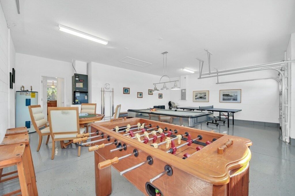 A room with a foosball table, a ping pong table, and a pool table.