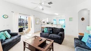 A modern living room with two sofas, a coffee table, and a ceiling fan. - Fantastic 4 Bedroom In Gated Community with Private Pool and Games Room Minutes to Disney (Davenport)