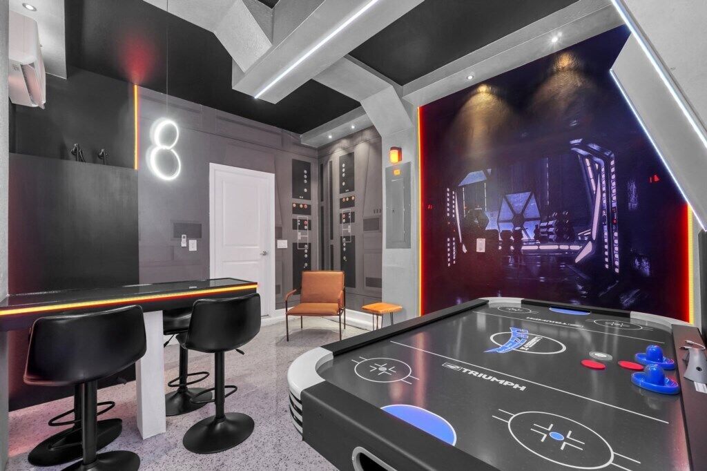 Zona de bar moderna con mesa de billar, taburetes y un letrero de neón.