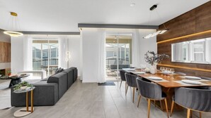 Un comedor moderno con una mesa de madera dispuesta para seis personas, rodeada de sillas grises.