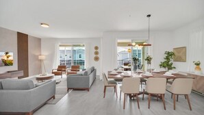Una sala de estar moderna con un sofá gris, una mesa de centro y un comedor con una mesa y sillas de madera.
