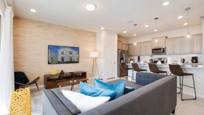 A modern living room with a grey sofa, blue cushions, and a wooden accent wall.