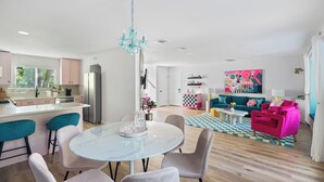 Un espacio de estar moderno con cocina, comedor y sala de estar con sofá y mesa de centro.