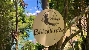 A sign with a bird logo and text reading "Lá Comarca Biénenido." - La Comarca Guatape (El Peñol)