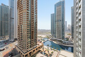 A high-rise building with multiple balconies, a river, and a marina with boats. - ME DO RE residence (Dubai)