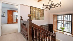 A staircase with wooden balusters and a chandelier. - Sutton Barton Farmhouse (Honiton)