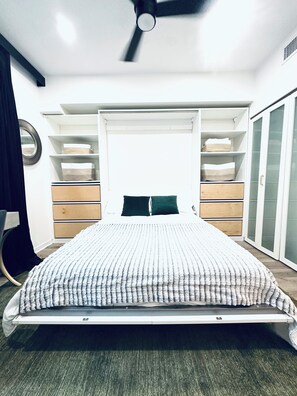 A bedroom with a bed, a ceiling fan, built-in storage, and a wardrobe. - Modern and Updated 2-bed/2-bath Condo in Silicon Valley! (Los Angeles)