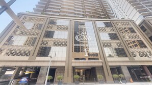 A high-rise building with a modern design, featuring geometric patterns on the facade and a prominent "Elite Downtown Residence" sign. - Elite Downtown Residences (Dubai)