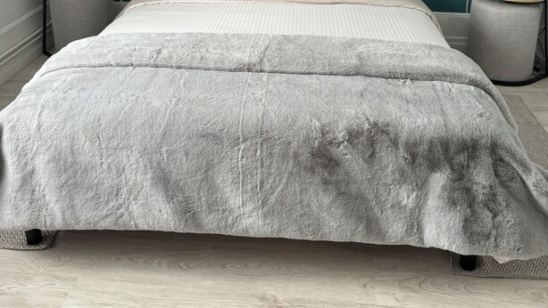 Ein Schlafzimmer mit einem Bett, zwei Nachttischen und einem an der Wand befestigten Bild einer Brücke.