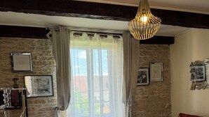 Ein gemütliches Wohnzimmer mit einer Steinwand, einem roten Sofa, einem Holztisch und einer hängenden Lampe.