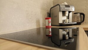 A modern kitchen with a built-in coffee maker and a coffee pot on the counter.