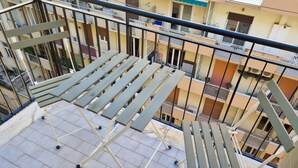 A balcony with a metal railing and a wooden table.