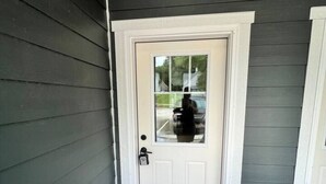 A dark grey exterior wall with a white door and a small doormat. - 404 Spacious 3 Bed 2 Bath Townhouse (Iowa City)