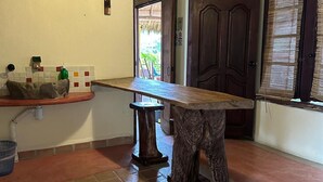 Une cuisine avec un plan de travail en bois, un évier et une porte donnant sur l’extérieur.
