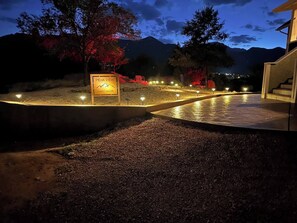 Een pension met een bord dat een prachtig uitzicht belooft, gelegen in een aangelegde omgeving met paden en verlichting.