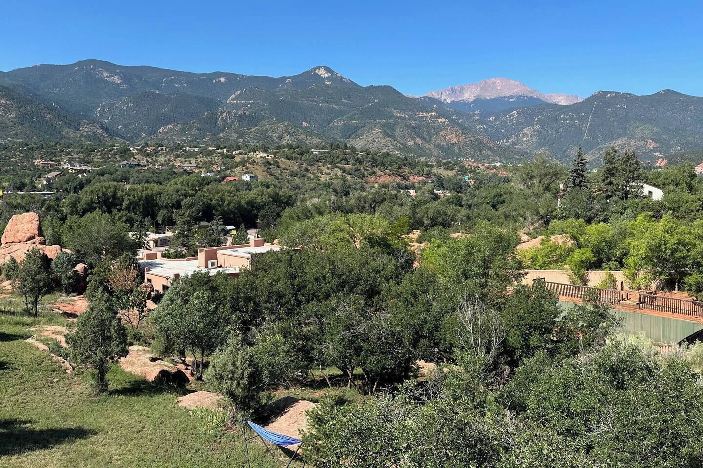 Paisagem montanhosa com edifícios dispersos e vegetação.