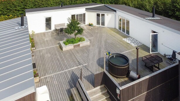 Una terrazza sul tetto con idromassaggio, zona salotto e un piccolo giardino.