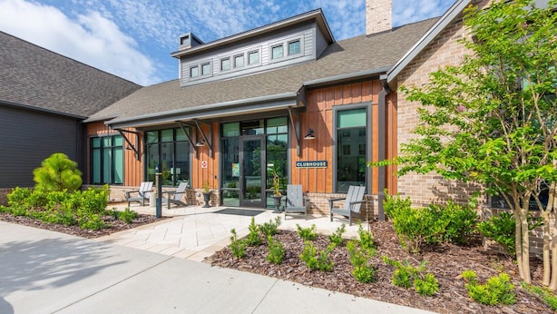 A clubhouse with a brick exterior, large windows, and outdoor seating area. - Tropical Retreat: Luxe 2BR/2BA with Pool & Gym (Jacksonville)