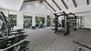 A modern gym with treadmills, a weight bench, and various exercise equipment. - Tropical Retreat: Luxe 2BR/2BA with Pool & Gym (Jacksonville)