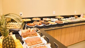 Un bufé con diversos alimentos, entre ellos frutas, pasteles y postres.