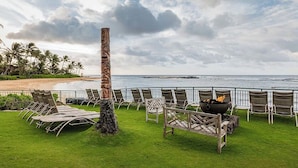 A beachside lounge with lounge chairs and a tiki-style pillar, overlooking the ocean. - OceanView Marriott Waiohai beach club 2BDRM villa , Full Resort Access  (Koloa)