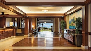A spacious lobby with a wooden floor, a reception desk, and a large mural of a mountain landscape. - OceanView Marriott Waiohai beach club 2BDRM villa , Full Resort Access  (Koloa)