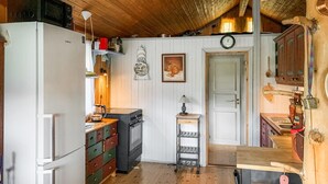 Una cocina compacta con refrigerador, estufa y armarios de madera.