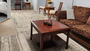 A living room with a sofa, coffee table, and chairs. There is a desk with a lamp and a picture on the wall. - Cozy Basement Apartment in Columbia  (Columbia)