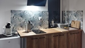 Une cuisine moderne dotée d’un plan de travail en bois, d’une bouilloire, d’une machine à café et d’un évier.