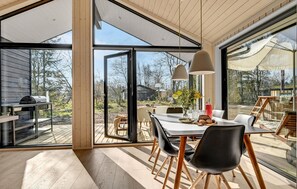 A spacious dining area with a large table, chairs, and a view of the outdoors.