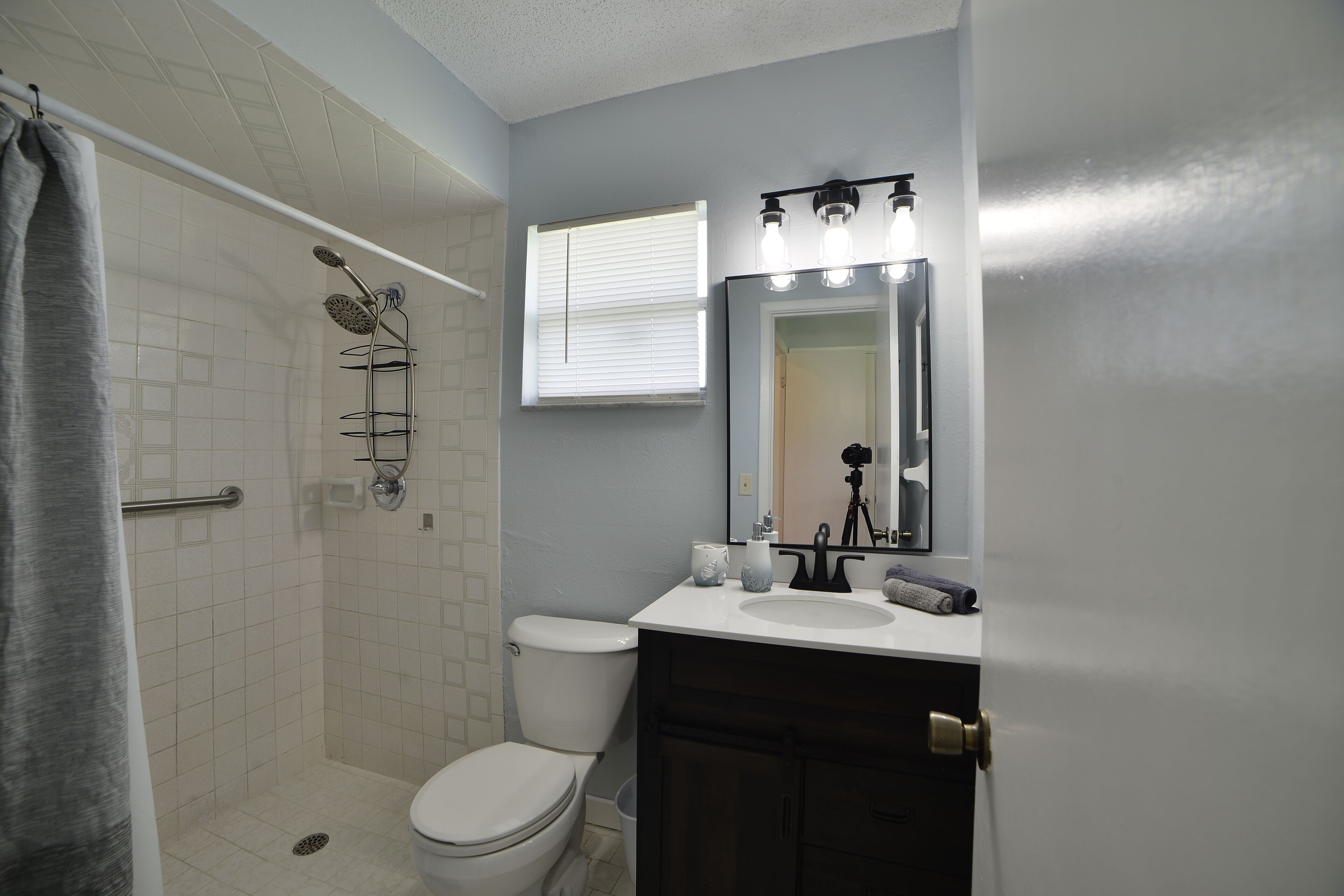 Une salle de bain équipée d’une douche, de toilettes, d’un lavabo et d’un miroir.
